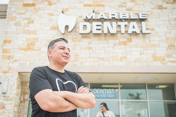 Older man with arms folded in front of Marble Dental McKinney