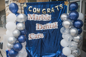 Blue curtain with words that read Congrats Marble Dental McKinney