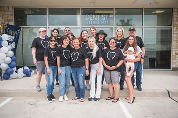 Dental team in matching shirts gathered for group picture