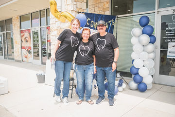 Three people with matching dental themed shirts
