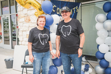 Two people standing in front of some balloons