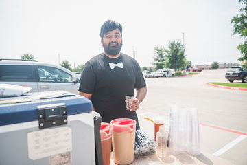 Man standing behind table holding cup