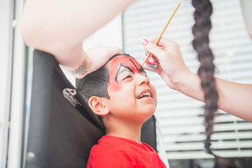 Little boy looking up and having his face painted