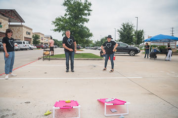 Head-on shot of two men playing beanbag toss