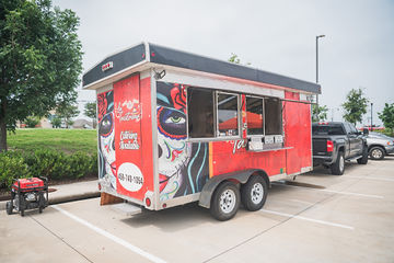 Orange food truck trailer hooked up to pickup