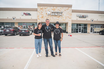 Three people standing in line in parking lot