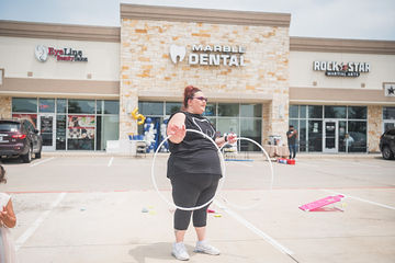 Woman holding two hoops in parking lot
