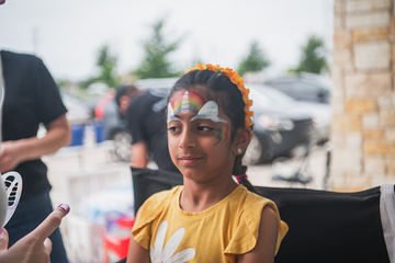Little girl sitting in a chair with her face painted