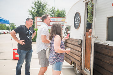 Multiple people gathered outside of a trailer