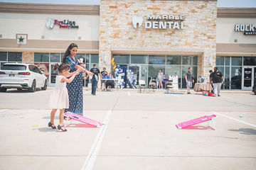 Woman and little girl playing bag toss