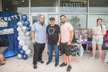 Three men standing in front of dental practice