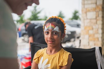 Little girl with unicorn horn and ears painted on forehead