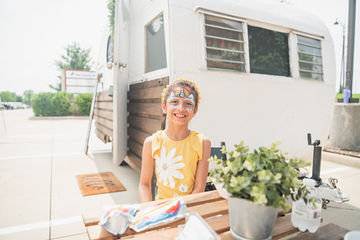 Little girl with face pain standing in front of trailer