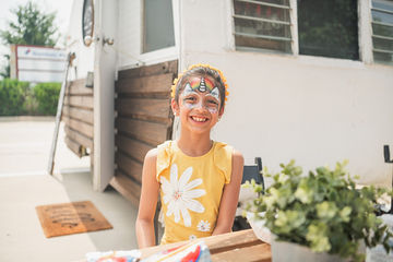 Close-up of little girl with face pain outside trailer