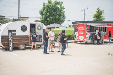 Far shot of two trailers with people walking around