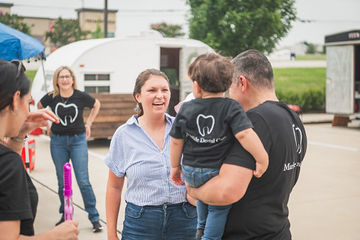 Woman talking to man holding a child