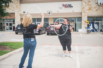 Two women facing each other and holding hoops