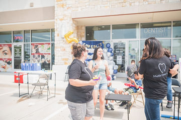 Three women talking in parking lot outside of dental office