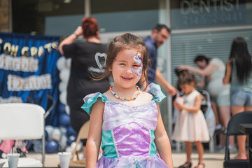 Laughing little girl with green and purple dress