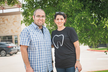 Man with patterned shirt and woman with shirt that has tooth on it
