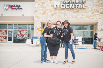 Three women with matching dental shirts in parking lot