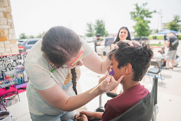 Side view of boy having face painted