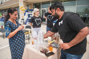 Man pouring drink for woman at outdoor table