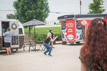 Far shot of woman in parking lot between two trailers