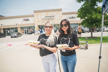 Two women holding food in parking lot
