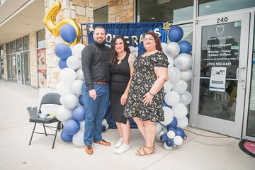 Three well-dressed people in front of door to dental office