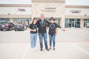 Three people standing in parking lot in front of Marble Dental McKinney