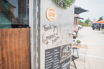 The words Thank You Marble Dental McKinney on a board