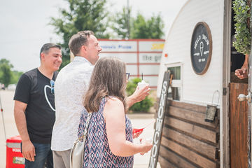 Three people standing at side of trailer