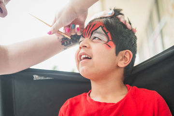 Close up of little boy receiving tiger face paint