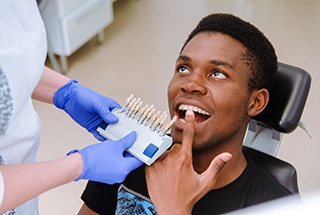 Male patient pointing to a tooth while in the dentist’s chair