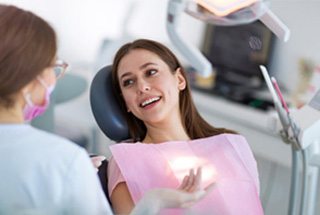 Woman talking to her dentist about dental bridges in McKinney