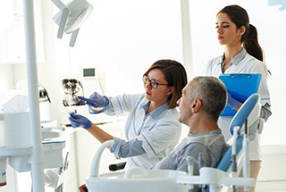 Dentist showing patient X-rays of smile