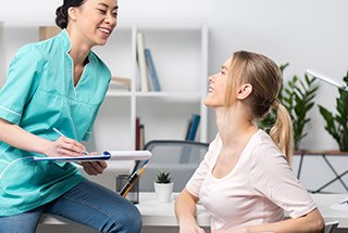 Dentist talking to patient in dental exam room