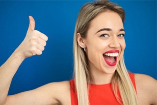 A woman smiling after receiving a dental crown in McKinney