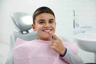 Young boy pointing to his tooth that received Curodont
