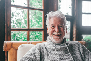 mature man smiling after getting dentures in McKinney