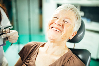 mature woman smiling in dental chair