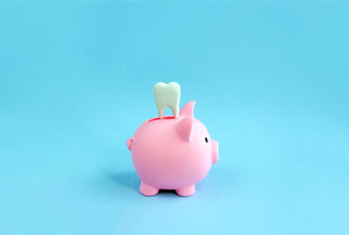Tooth and piggy bank for cost of tooth extractions in McKinney