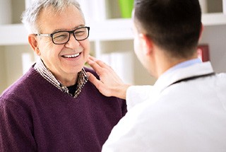 Senior man smiling and speaking to dentist