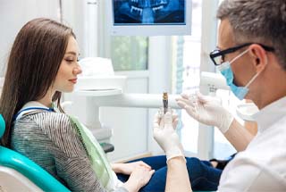 implant dentist in McKinney showing a dental implant to a patient