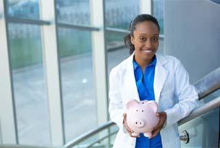 smiling dentist holding a pink piggy bank