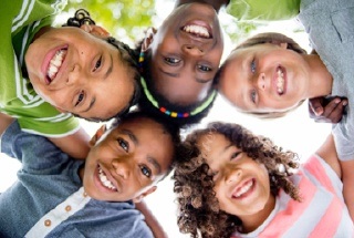 Children in circle formation smiling down at camera