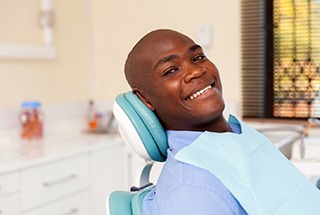 person smiling and sitting in a dental chair