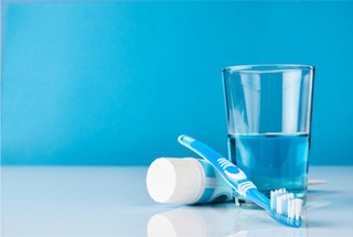 Toothbrush toothpaste and mouthwash arranged on countertop