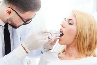 Woman getting her teeth and gums checked at dental office